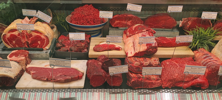 Assorted fresh beef cuts arranged in a butcher display counter